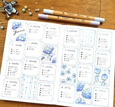 a planner with blue flowers on it next to two pencils and some other items