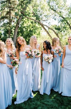 a group of women standing next to each other holding bouquets