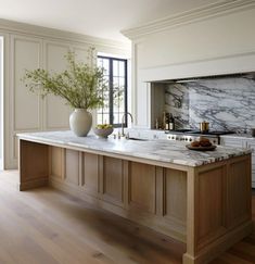 a large kitchen with marble counter tops and wooden cabinets, along with an island in the middle