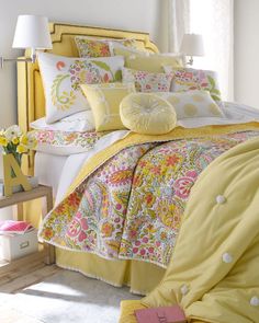 a bed with yellow comforters and pillows