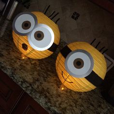 two yellow and black paper lanterns with eyes on them