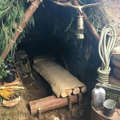 there is a tent made out of logs and rope with a lantern hanging from the ceiling