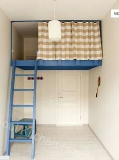 a blue bunk bed sitting in the corner of a room