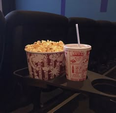 two cups of popcorn sitting on top of a table