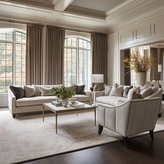 a living room filled with lots of furniture and large windows in the wall behind them