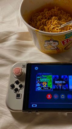 a nintendo wii game system next to a bowl of noodles