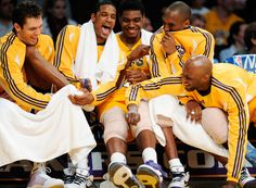 the basketball players are sitting on the bench and having a good time with each other