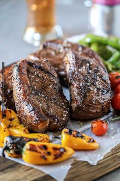 grilled steaks and vegetables on a cutting board