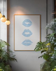 an art print hangs on the wall next to potted plants and hanging light bulbs