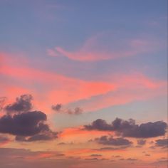 the sky is pink and blue with clouds in it at sunset or dawn, as seen from an ocean shore