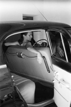 a woman sitting in the driver's seat of a car