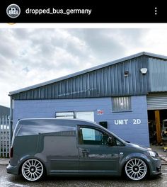 a grey van parked in front of a blue building