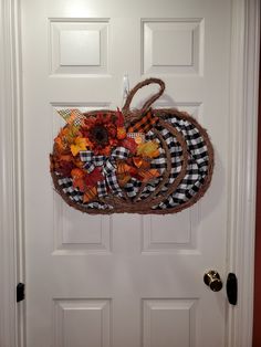 a white door with a black and white checkered pumpkin decoration hanging from it's side