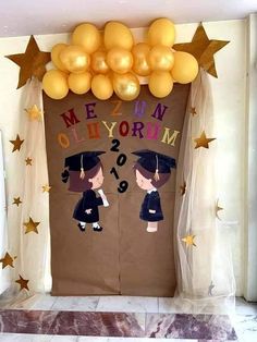 a door decorated with balloons and decorations for a graduation party in the shape of two graduates