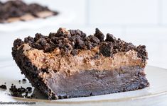 a slice of chocolate cheesecake on a plate with oreo crust and crumbs