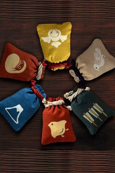 six small pouches with different designs on them sitting on a wooden table, each containing an individual's own logo