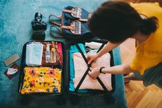 a woman packing her luggage on the floor