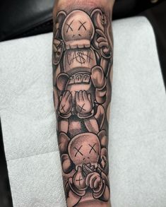 a person with a tattoo on their arm holding a teddy bear in front of them