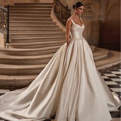 a woman in a wedding dress standing on stairs