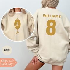 All of our Custom Football hoodies are handmade to order on an ultra soft crewneck that will quickly become your go to apparel item! You will never want to take it off! Our Football Name and Number sweatshirts are handmade to order with eco-friendly water based ink that feels good and lasts longer! ♥The details♥ This unisex sweatshirt is crafted from soft, breathable fabric for ultimate comfort. Printed with an eco-friendly water-based ink, this sweater not only looks great but also supports sustainable practices. The unisex sizing allows for a versatile fit, but we suggest sizing up for a more relaxed look. To keep your crewneck looking its best, we recommend washing it on cold and either hanging it to dry or tumble drying it on low heat. Be sure to avoid ironing directly on the design to Game Day Fleece Hoodie With Crew Neck, Customizable Crew Neck Hoodie For Sports Events, Pre-shrunk Crew Neck Hoodie For Fan Gear, Fan Apparel Long Sleeve Sweatshirt With Custom Print, Customizable Sporty Crew Neck Hoodie, Custom Print Long Sleeve Sweatshirt For Sports, Long Sleeve Sweatshirt With Custom Print For Fans, Team Spirit Long Sleeve Sweatshirt With Custom Print, Customizable Casual Sweatshirt For Football Season