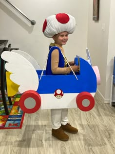 a young boy dressed up as a train with a mushroom on it's head