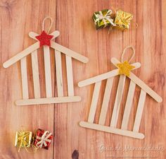 two popsicle houses are decorated with gold and red bows, one is shaped like a house