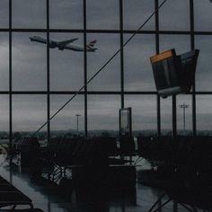 an airplane is flying over the airport through some windows