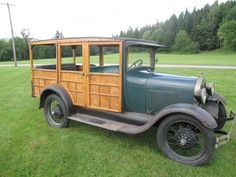 an old car is parked in the grass