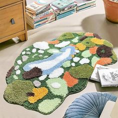 two rugs on the floor in front of a table with books and magazines next to it