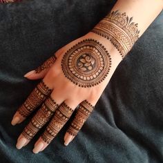 a woman's hand with henna tattoos on it