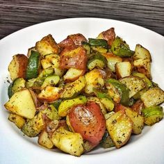 a white plate topped with potatoes and veggies