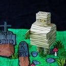 there is a cake made to look like a graveyard with tombstones and graves on it