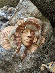 the head of a person wearing a hat with feathers on it's face is shown from above