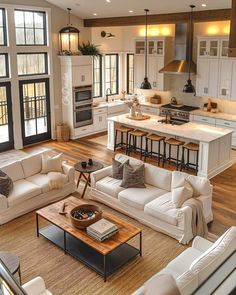 a living room filled with furniture next to a kitchen and an open concept floor plan