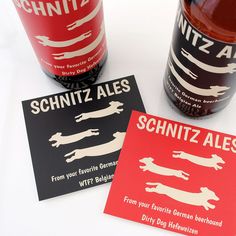 two cards with german beer labels next to each other on a white surface, one is red and the other is black