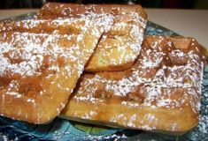 three pieces of french toast on a plate with powdered sugar