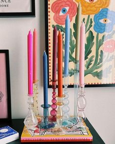 there are many candles that are on the table next to each other and some pictures