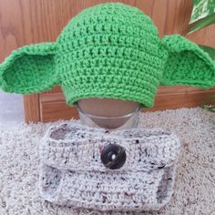 a crocheted yoda hat sitting on top of a table next to a purse