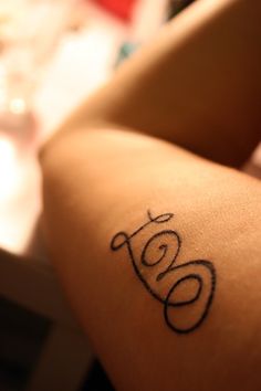 a woman's arm with the word love tattooed on it