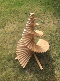 a sculpture made out of cardboard sitting in the grass