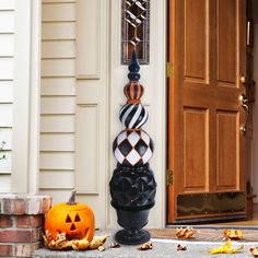 two pumpkins sitting on the ground in front of a door with an ornate clock