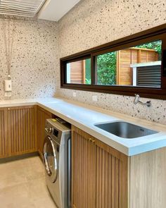 a washer and dryer in a room with wood paneling on the walls