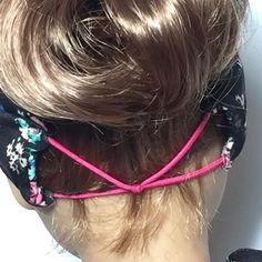 the back of a woman's head wearing a black and pink hair tie