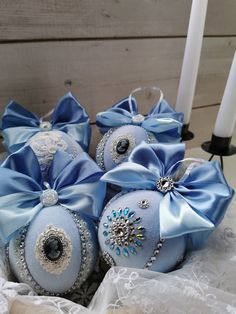 four blue christmas balls with bows on them