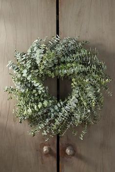 a wreath hanging on the side of a wooden door