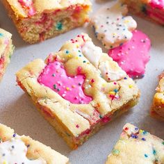 colorful cookies and sprinkles are arranged on a baking sheet with white frosting