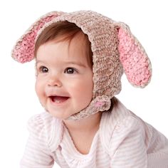 a smiling baby wearing a bunny hat