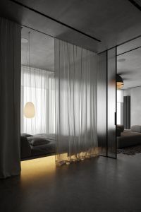 an empty room with sheer curtains and a bed in the corner next to a window