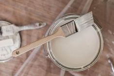 a paint can with a brush on top of it