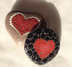 two rocks with hearts painted on them sitting next to each other